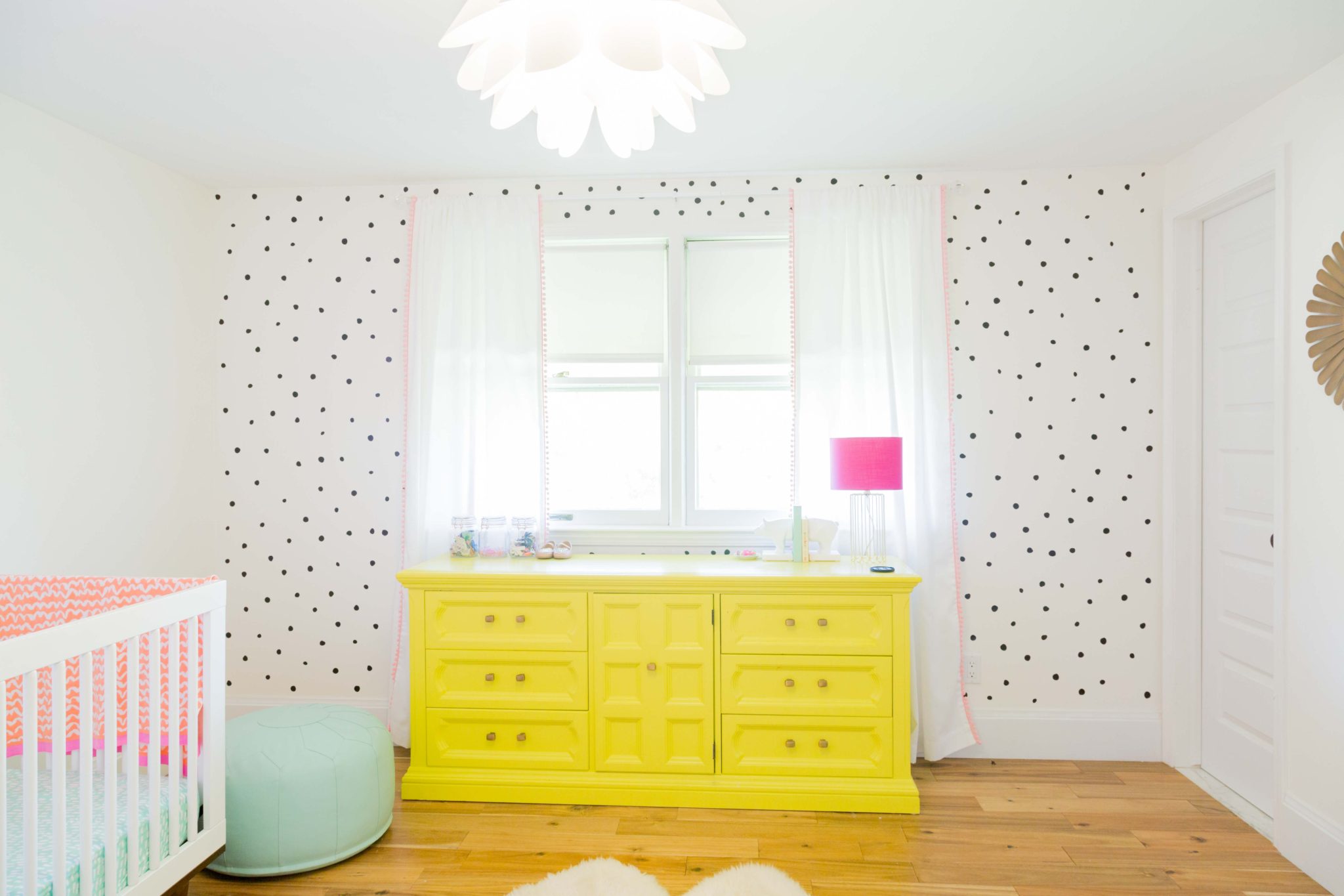 pretty and bright girls bedroom | bright nursery for baby girl | yellow dresser | the lovely wall co. decals | ikea picture ledge bookshelves | allweareblog.com